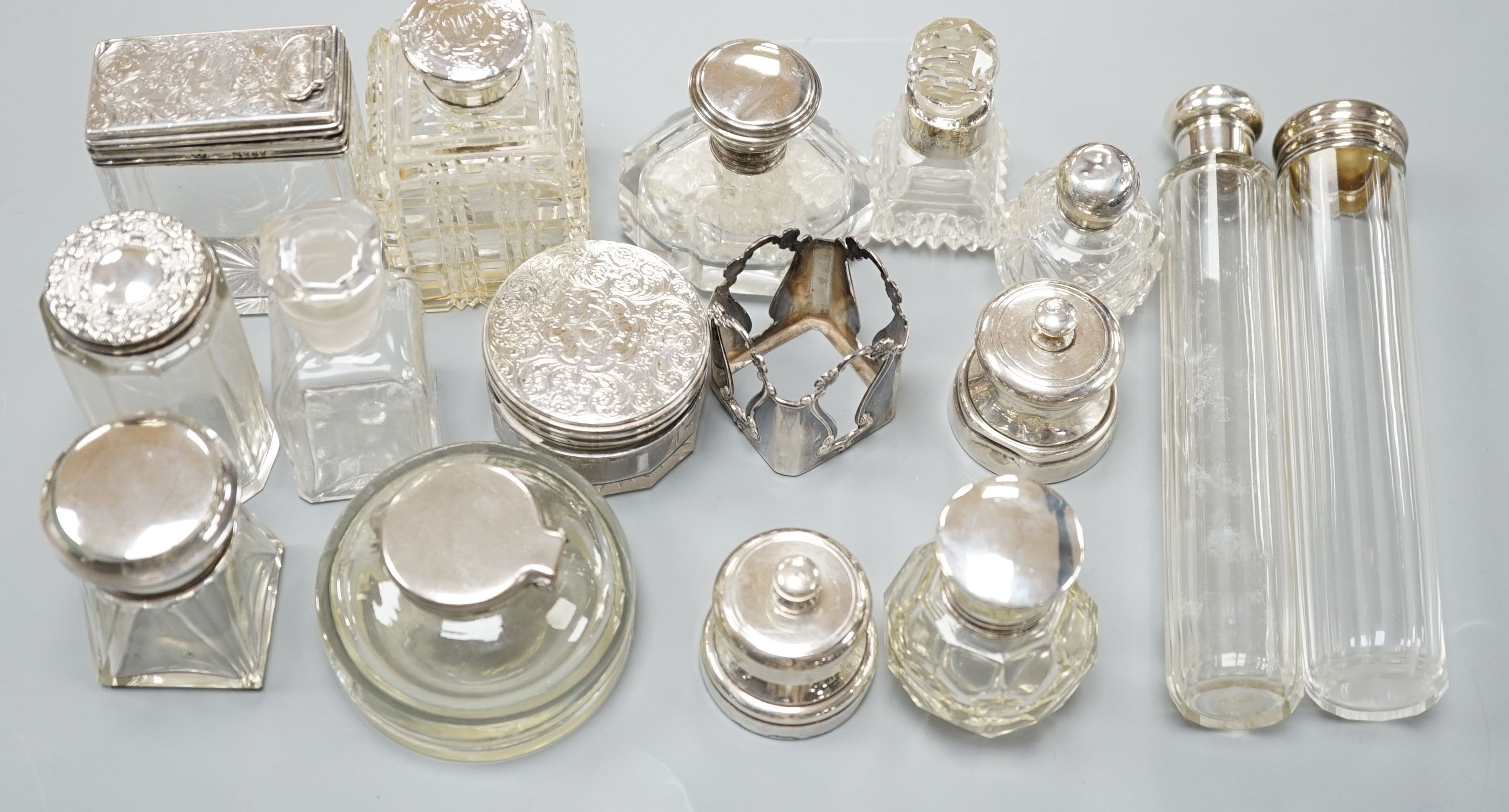 A collection of twelve assorted silver mounted glass toilet jars including Victorian, a plate mounted inkwell and a small pair of silver mounted salt and pepper mills.